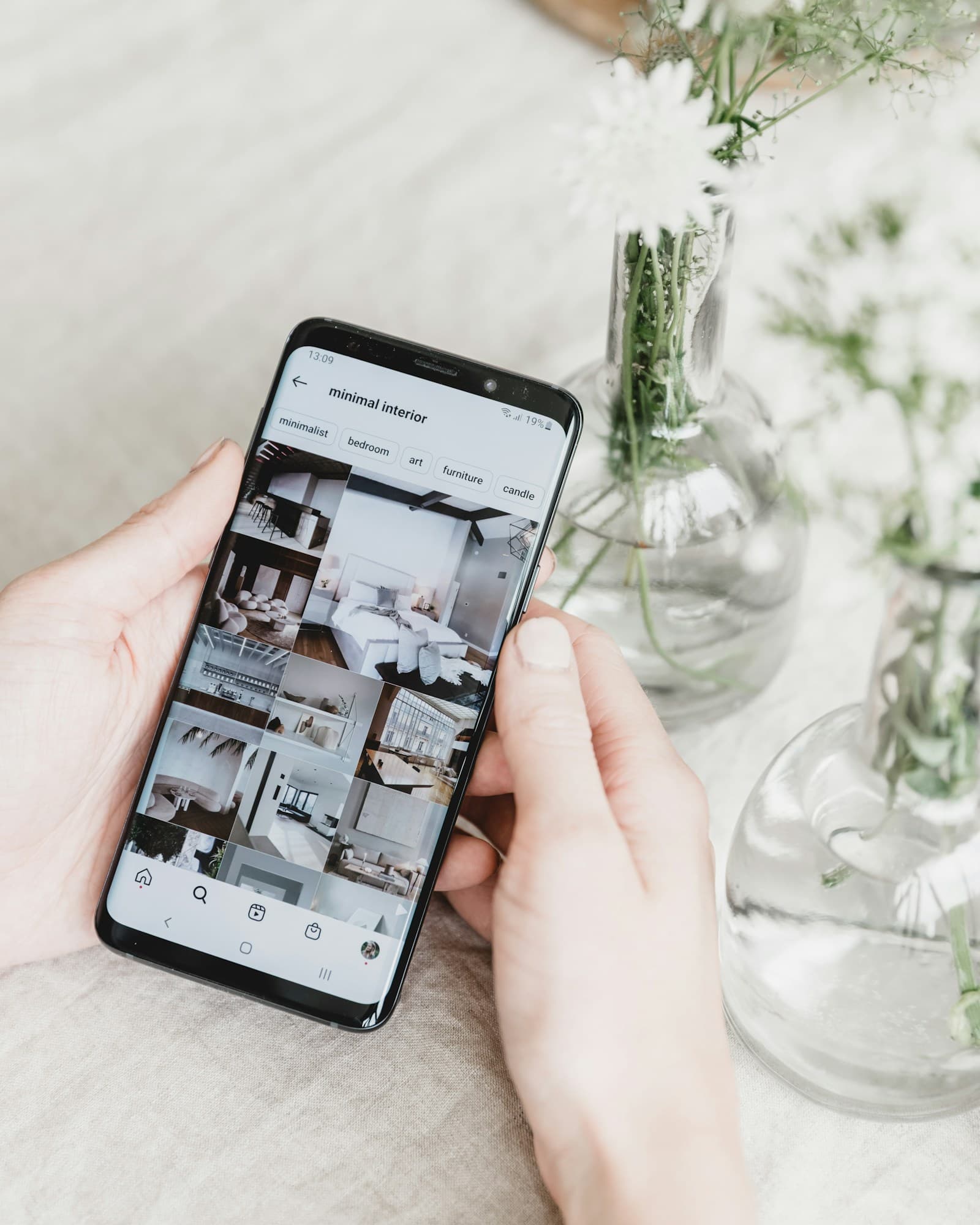 A hand holding a phone while browsing Instagram